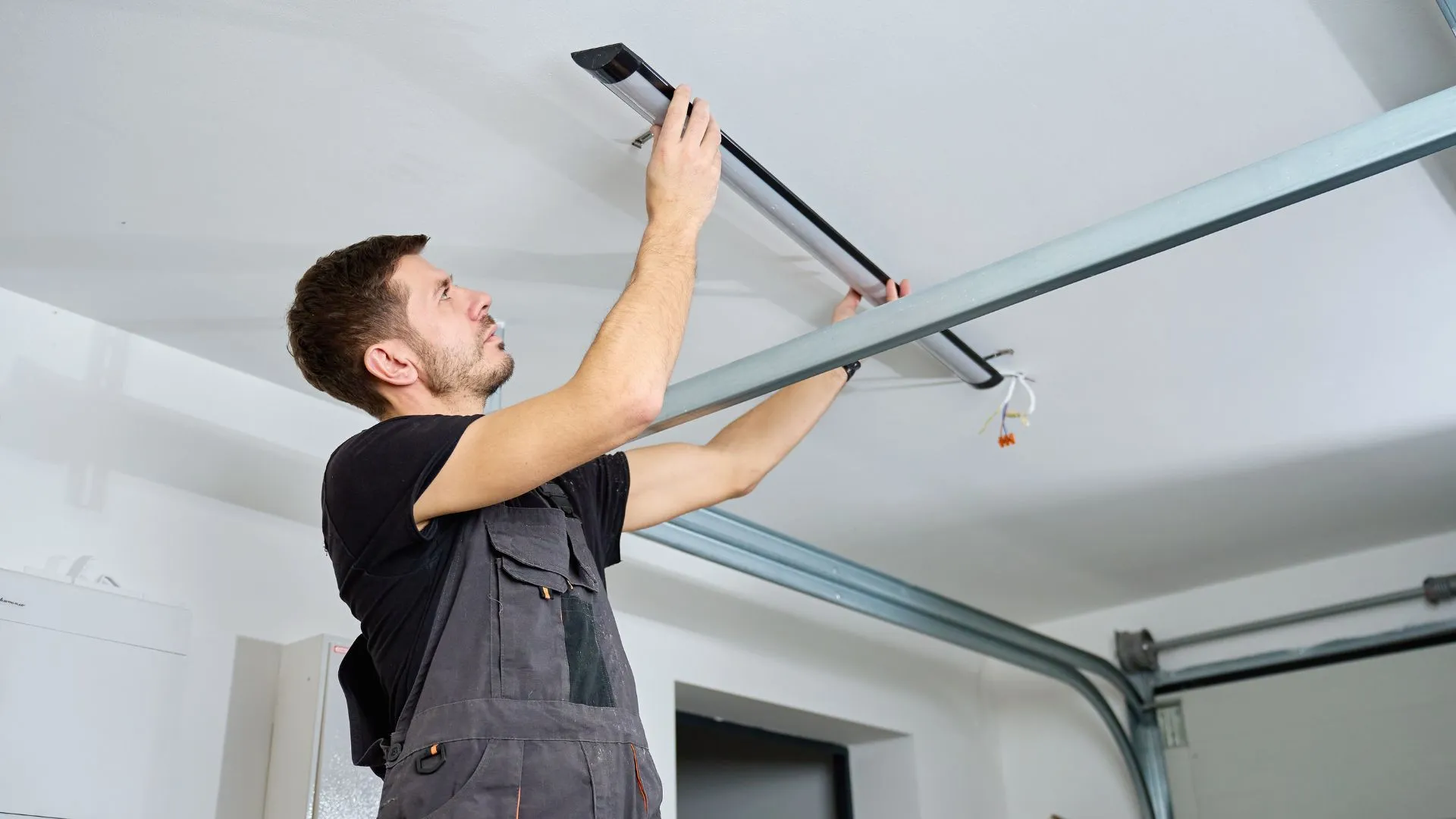 Technician installing a garage door opener track